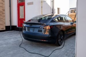 Black electric car is being charged at station